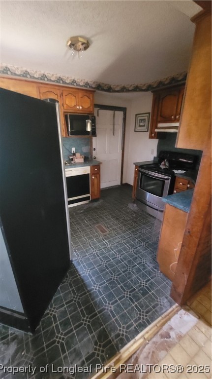174 Jane Road Maxton, NC 28364 - Photo 3 of 6 a kitchen with granite countertop a stove and a refrigerator