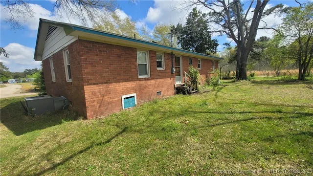 a front view of house with yard and trees in the background