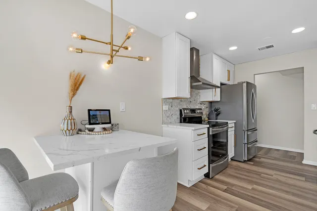 a kitchen with refrigerator cabinets and wooden floor