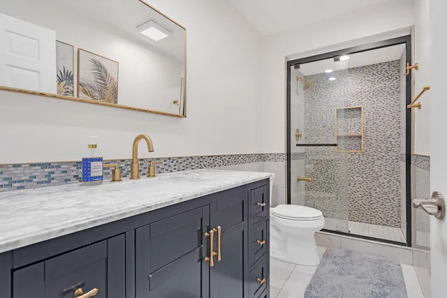 a bathroom with a sink a toilet and shower