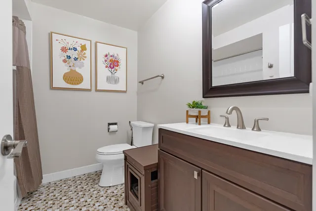 a bathroom with a sink mirror vanity and toilet