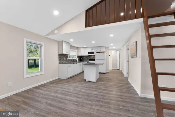 a view of kitchen with stainless steel appliances refrigerator oven and cabinets