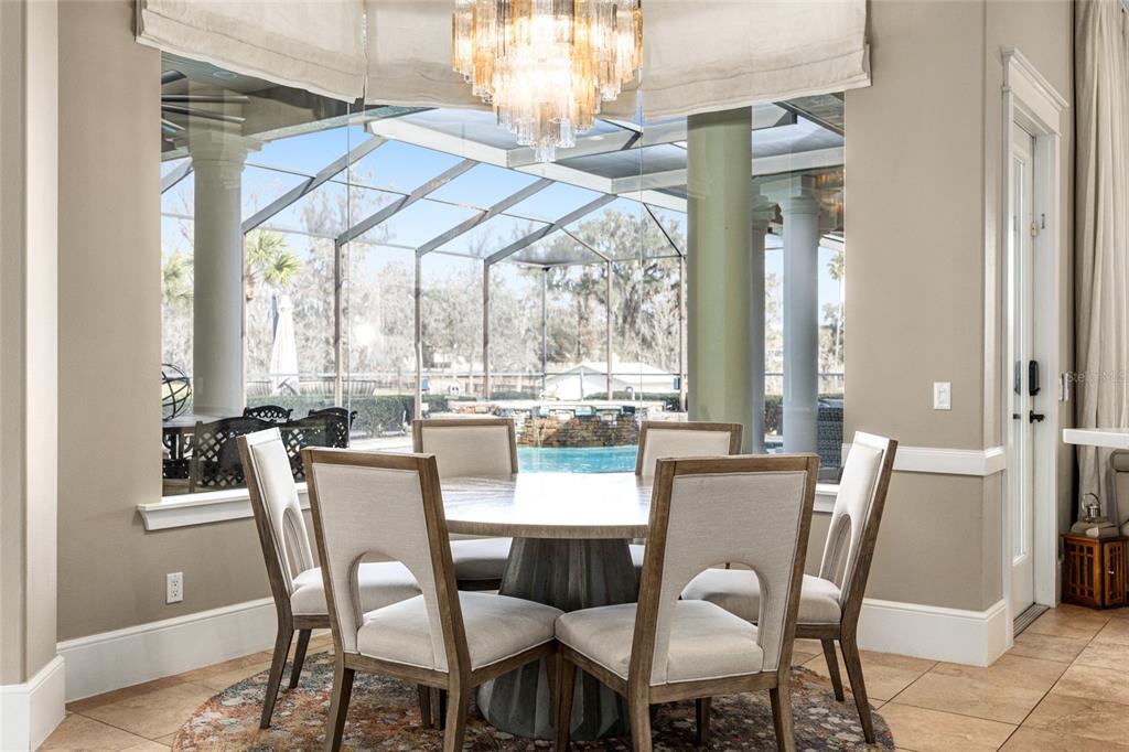 9389 Southwest 14th Avenue Ocala, FL 34476 - Photo 14 of 59 a dining room with furniture a chandelier and wooden floor