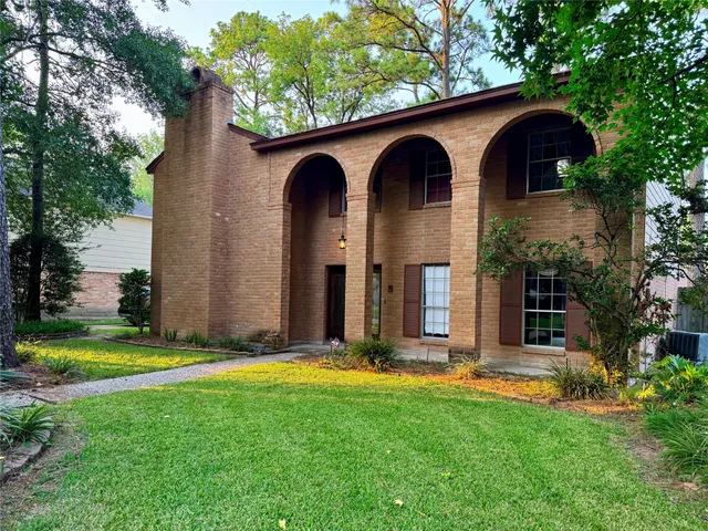 a front view of a house with yard and trees
