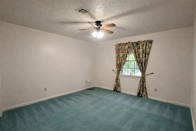 an empty room with closet and windows