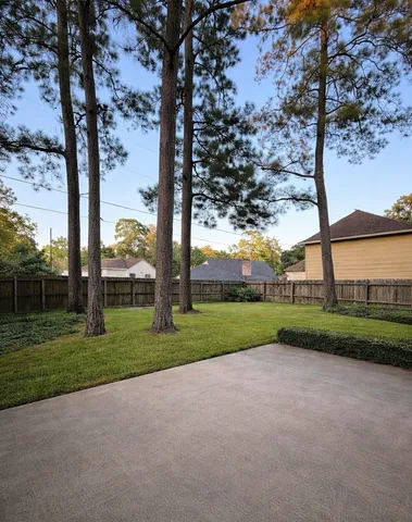 a view of green field with large trees
