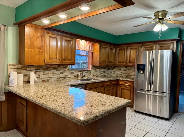 a kitchen with stainless steel appliances granite countertop a sink a stove and a refrigerator