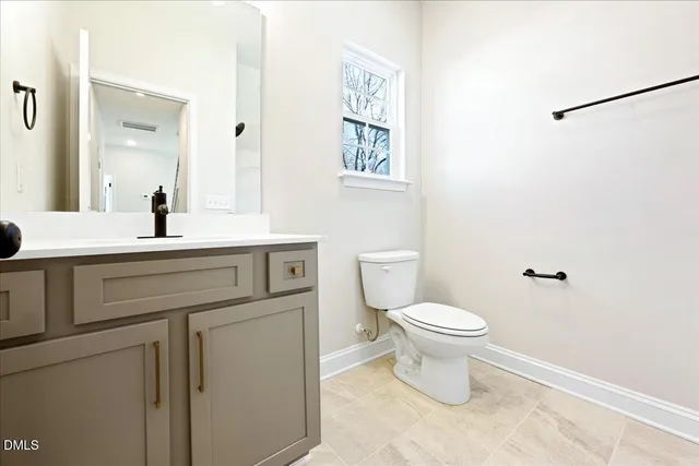 a bathroom with a toilet sink and a mirror