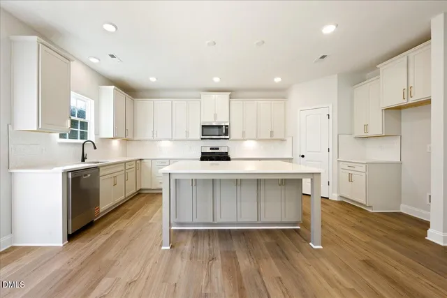 a kitchen with a white wooden cabinets and white stainless steel appliances