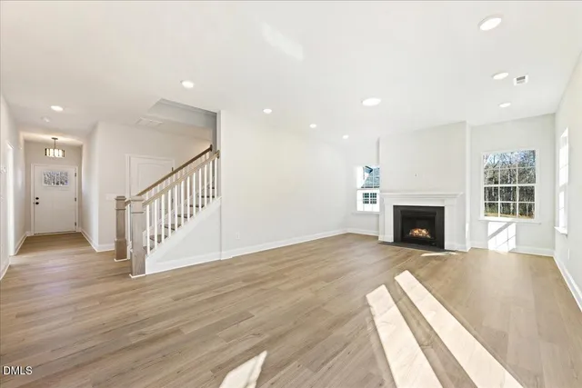 a view of a livingroom with wooden floor and a fireplace