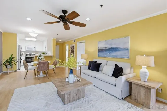 a living room with furniture kitchen view and a chandelier