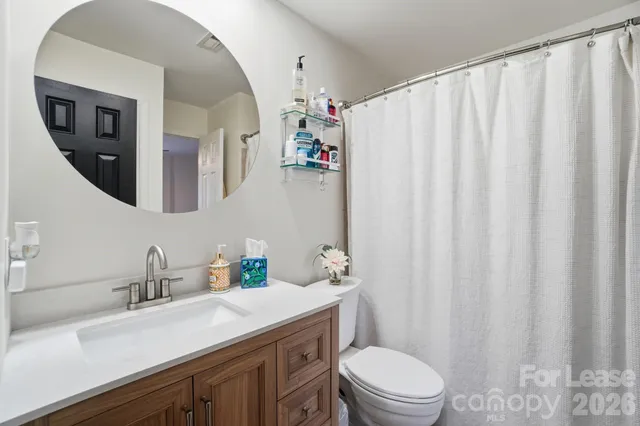 a bathroom with a sink a toilet and shower curtain