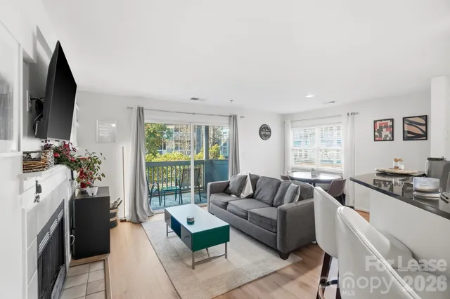 a living room with furniture a flat screen tv and a large window