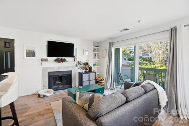a living room with furniture a flat screen tv and a fireplace
