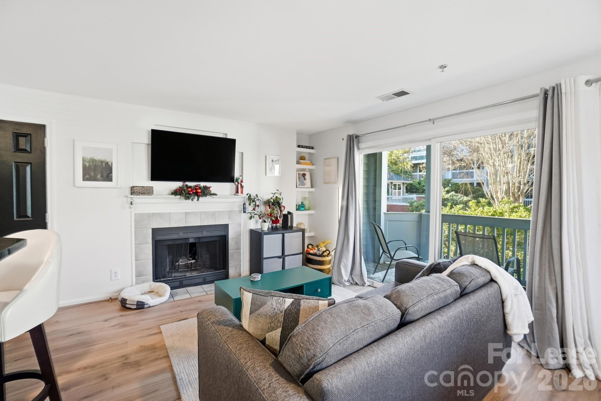 525 North Graham Street, Unit 2F Charlotte, NC 28202 - Photo 5 of 18 a living room with furniture a flat screen tv and a fireplace