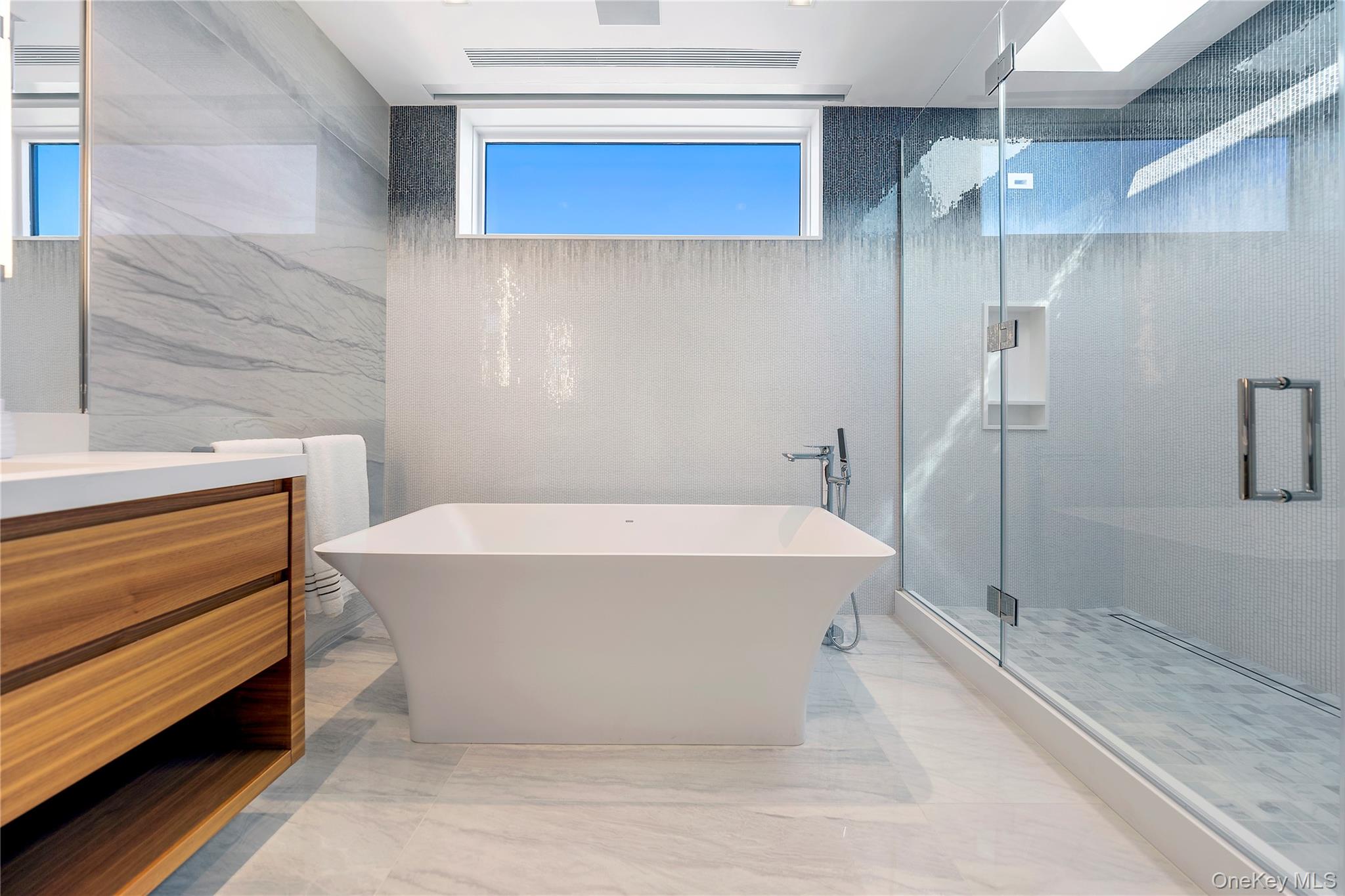 345 Dune Road Westhampton Beach, NY 11978 - Photo 16 of 34 Bathroom with vanity, a soaking tub, a marble finish shower, tile walls, and light marble finish flooring