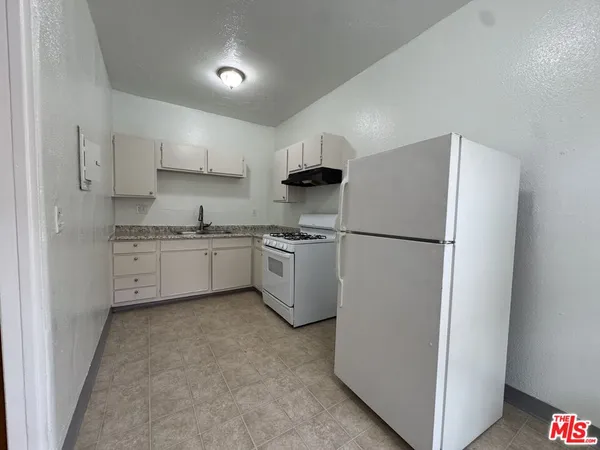 a kitchen with a refrigerator a sink and cabinets