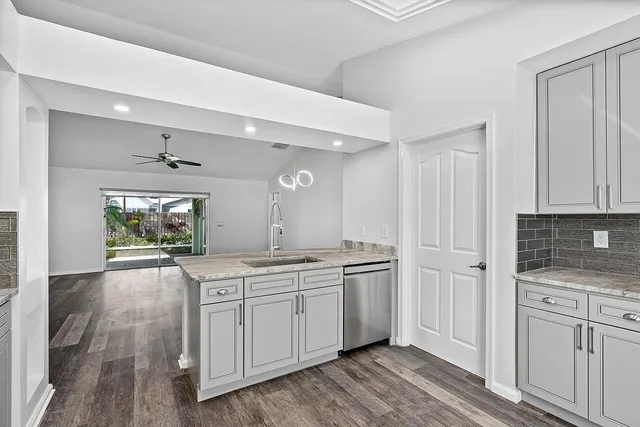 a spacious bathroom with a granite countertop sink a mirror and a bathtub