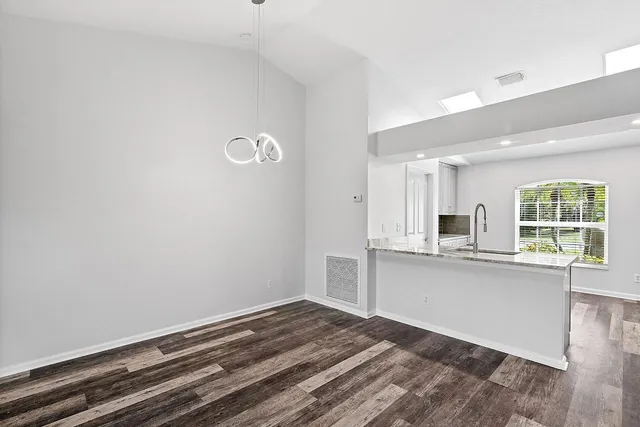 a view of a kitchen with wooden floor and a window