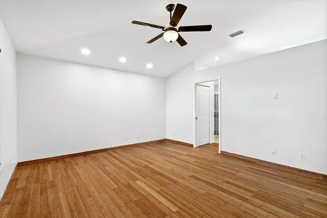 a view of an empty room with wooden floor