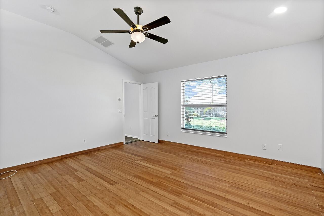 1374 Southeast Concha Street Port St. Lucie, FL 34983 - Photo 19 of 29 an empty room with wooden floor and windows