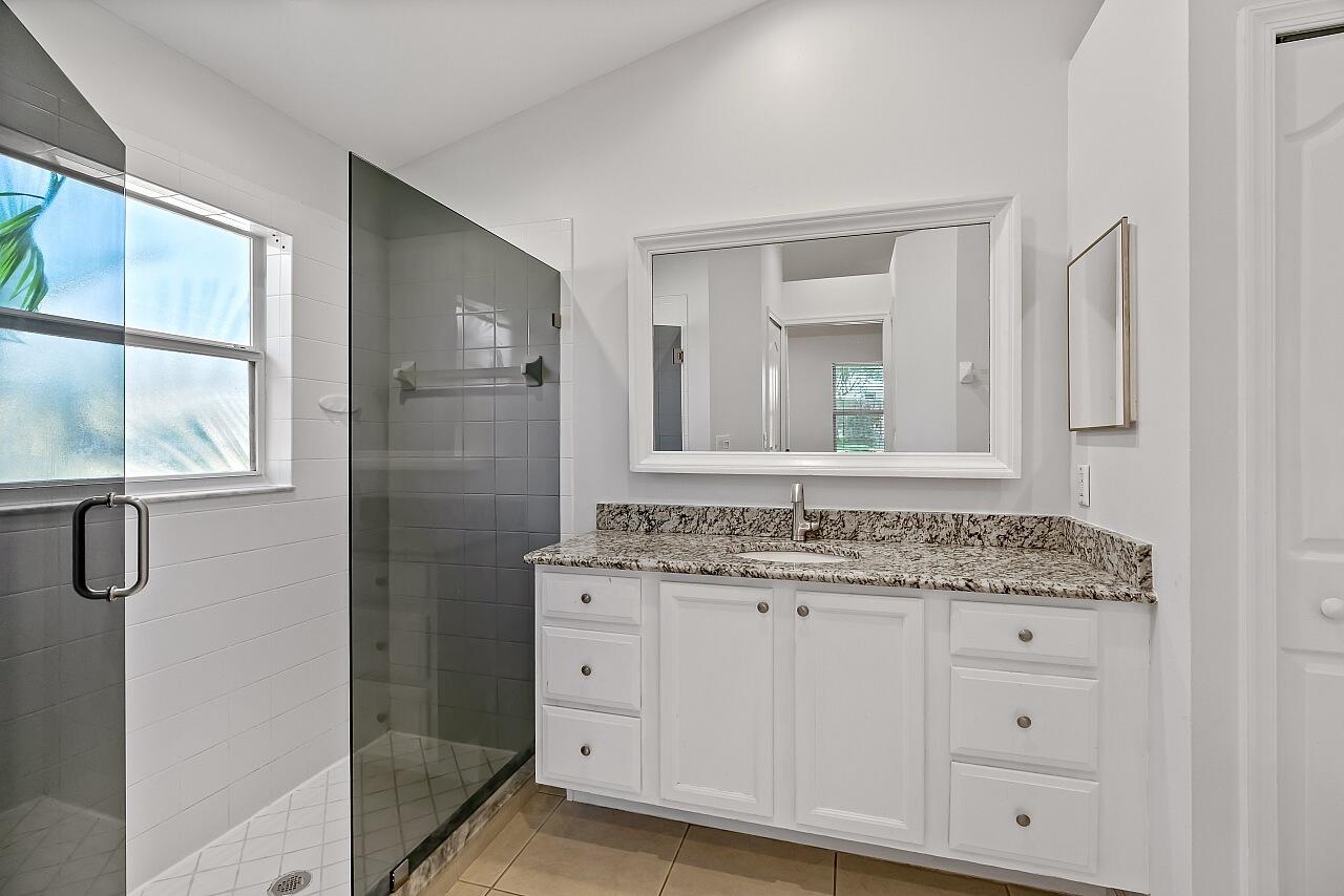 1374 Southeast Concha Street Port St. Lucie, FL 34983 - Photo 20 of 29 a bathroom with a granite countertop sink vanity mirror next to a cabinet