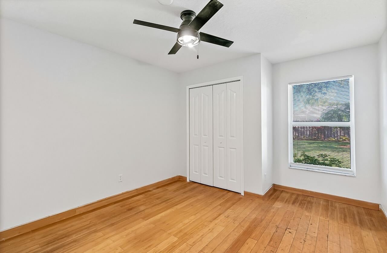 1374 Southeast Concha Street Port St. Lucie, FL 34983 - Photo 21 of 29 a view of empty room with wooden floor and fan