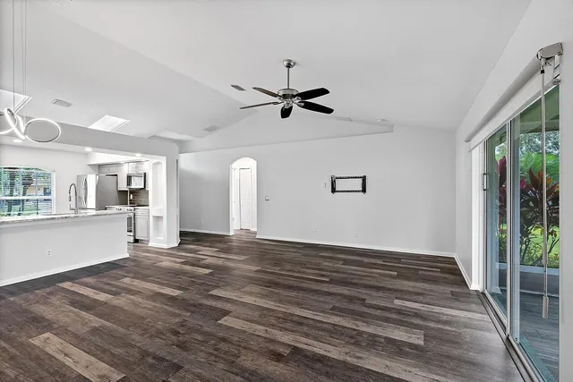 a view of an empty room with window and wooden floor