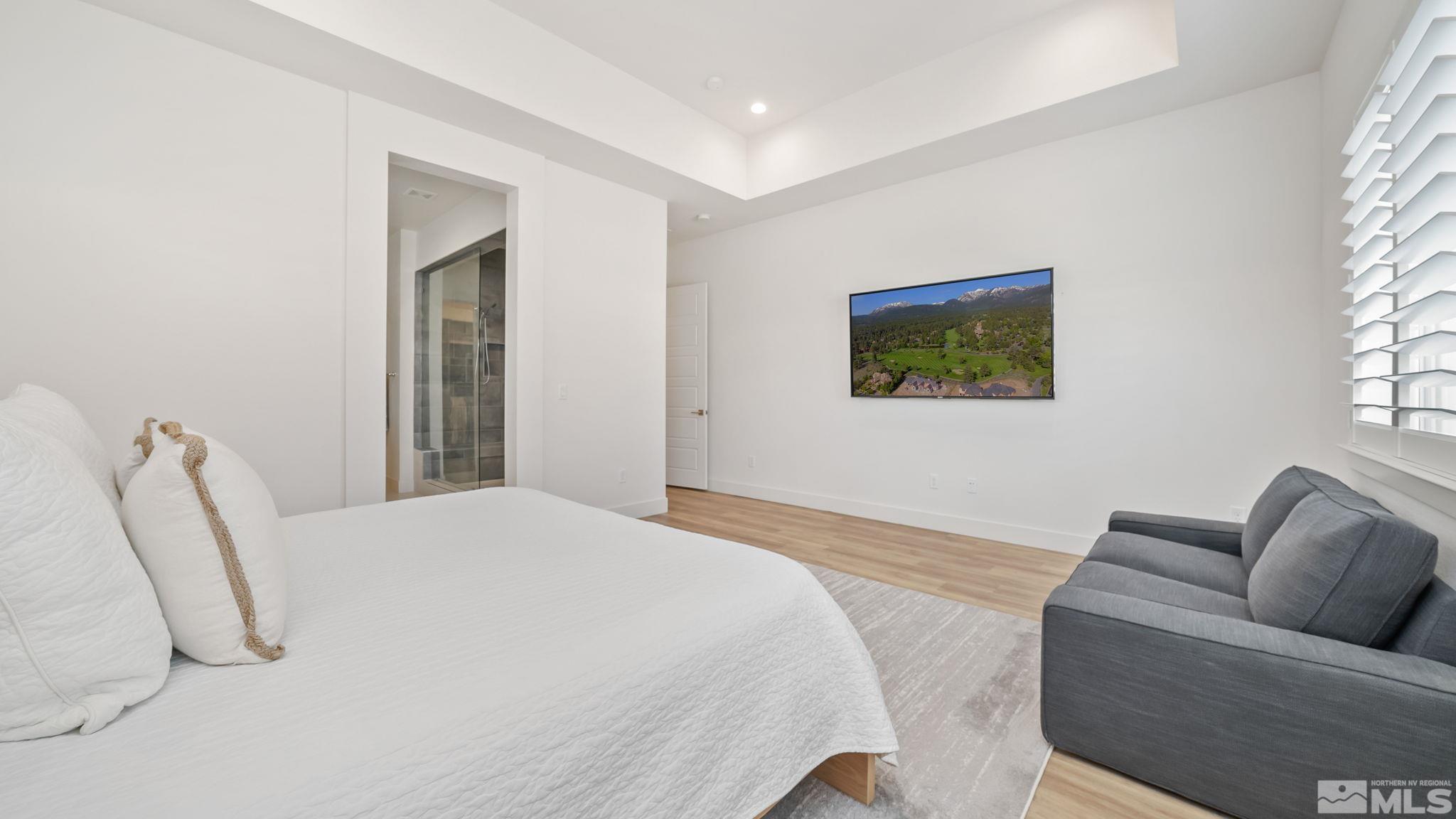 13550 Water Willow Street Reno, NV 89521 - Photo 21 of 37 a spacious bedroom with a bed and a couch