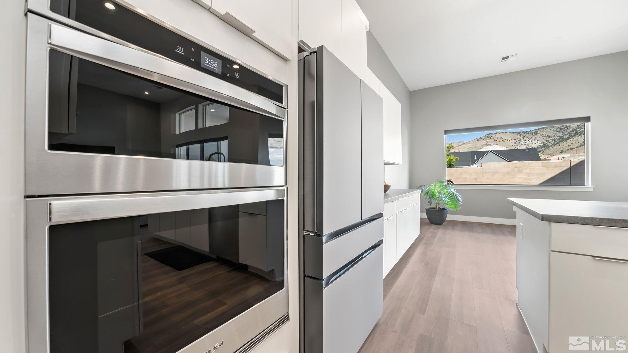 13550 Water Willow Street Reno, NV 89521 - Photo 9 of 37 a kitchen with white cabinets and black stainless steel appliances