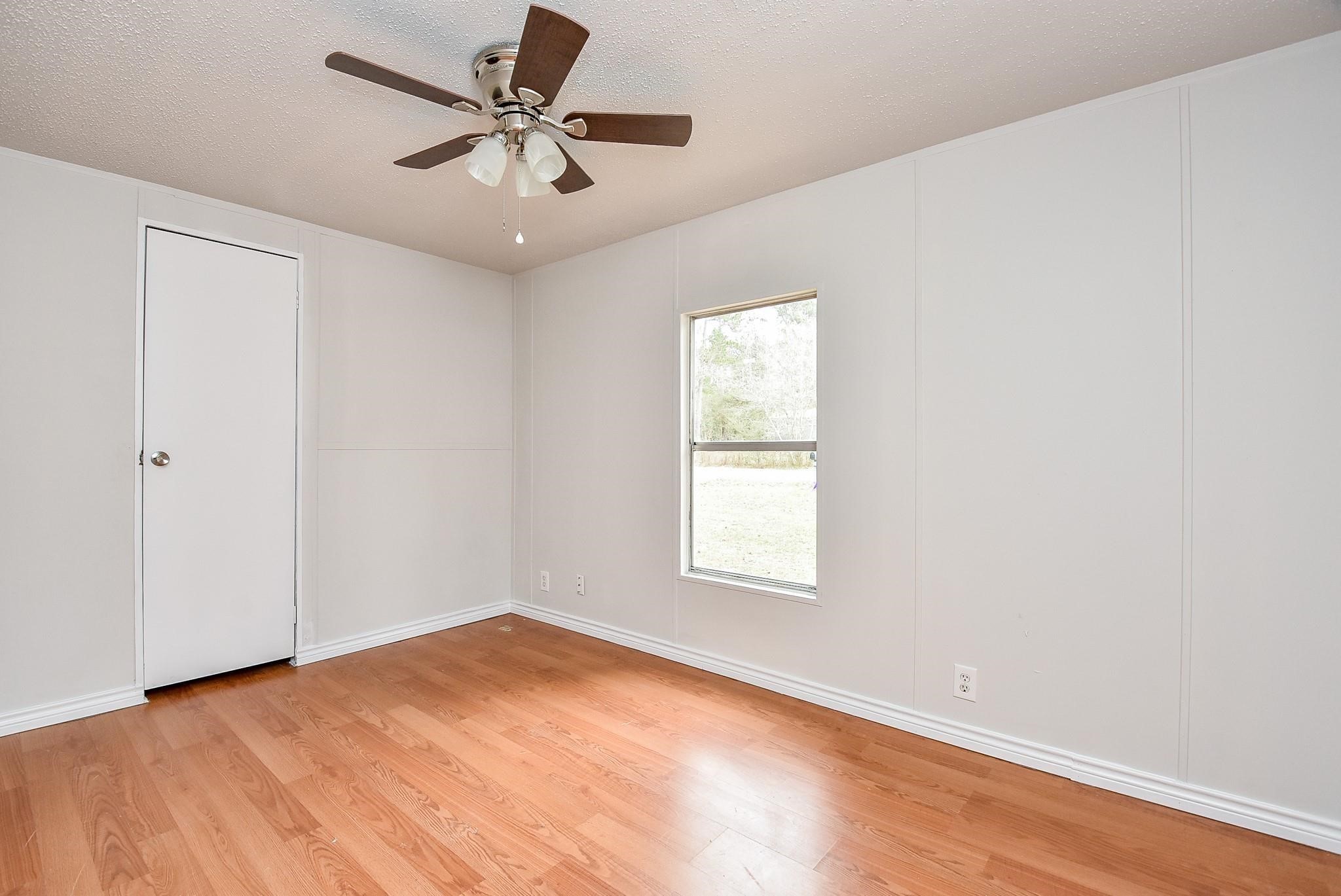 12842 Roy Harris Loop Conroe, TX 77306 - Photo 33 of 36 an empty room with windows and fan