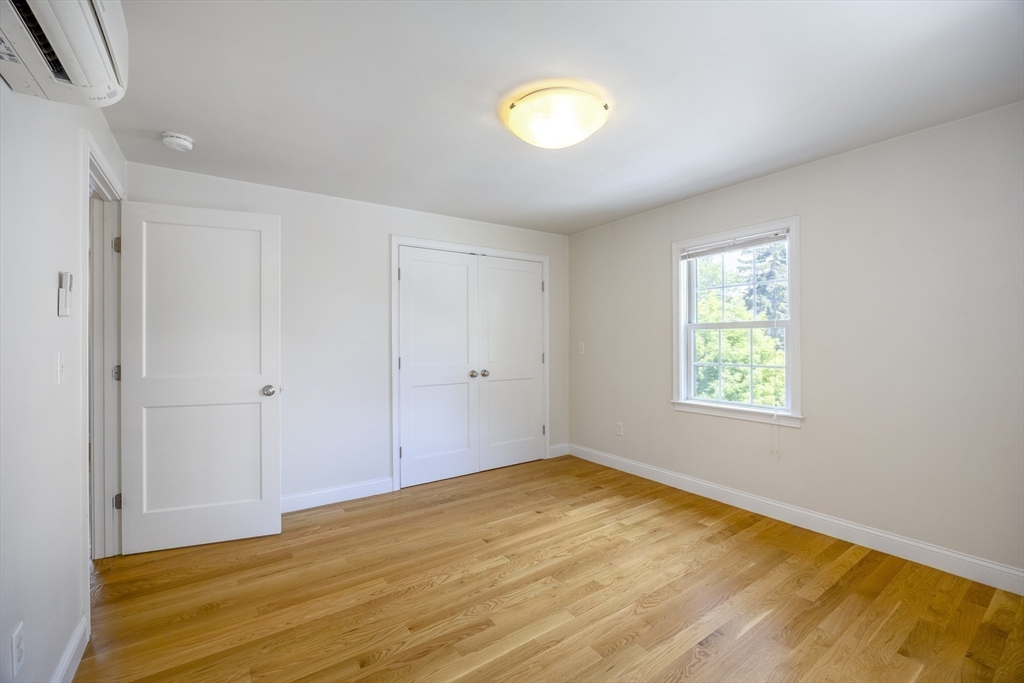 48 Spruce Street, Unit 1 Winchester, MA 01890 - Photo 8 of 29 a view of empty room with wooden floor and fan