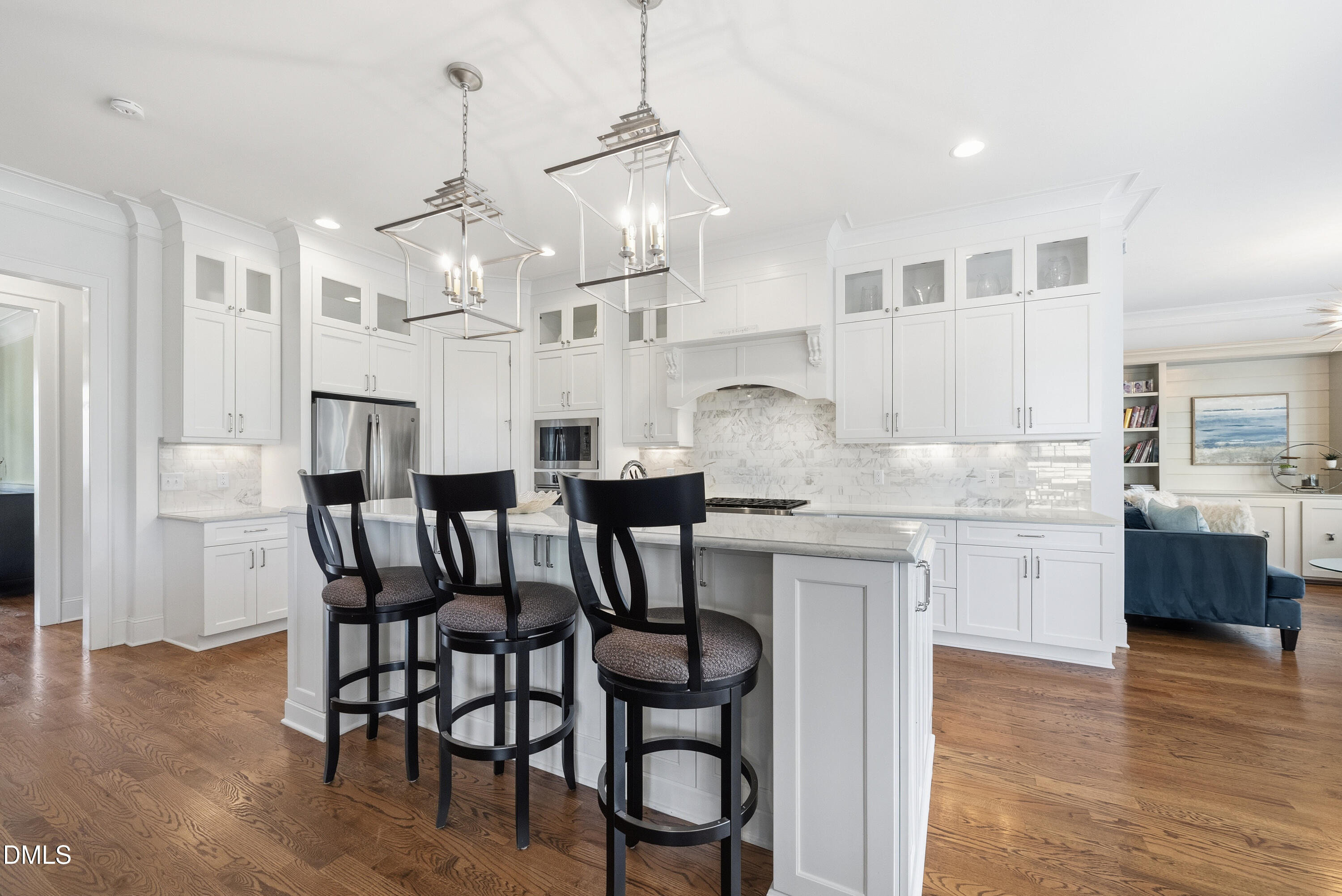 5109 Wainscott Way Raleigh, NC 27612 - Photo 11 of 52 a kitchen with granite countertop a table chairs stove and white cabinets