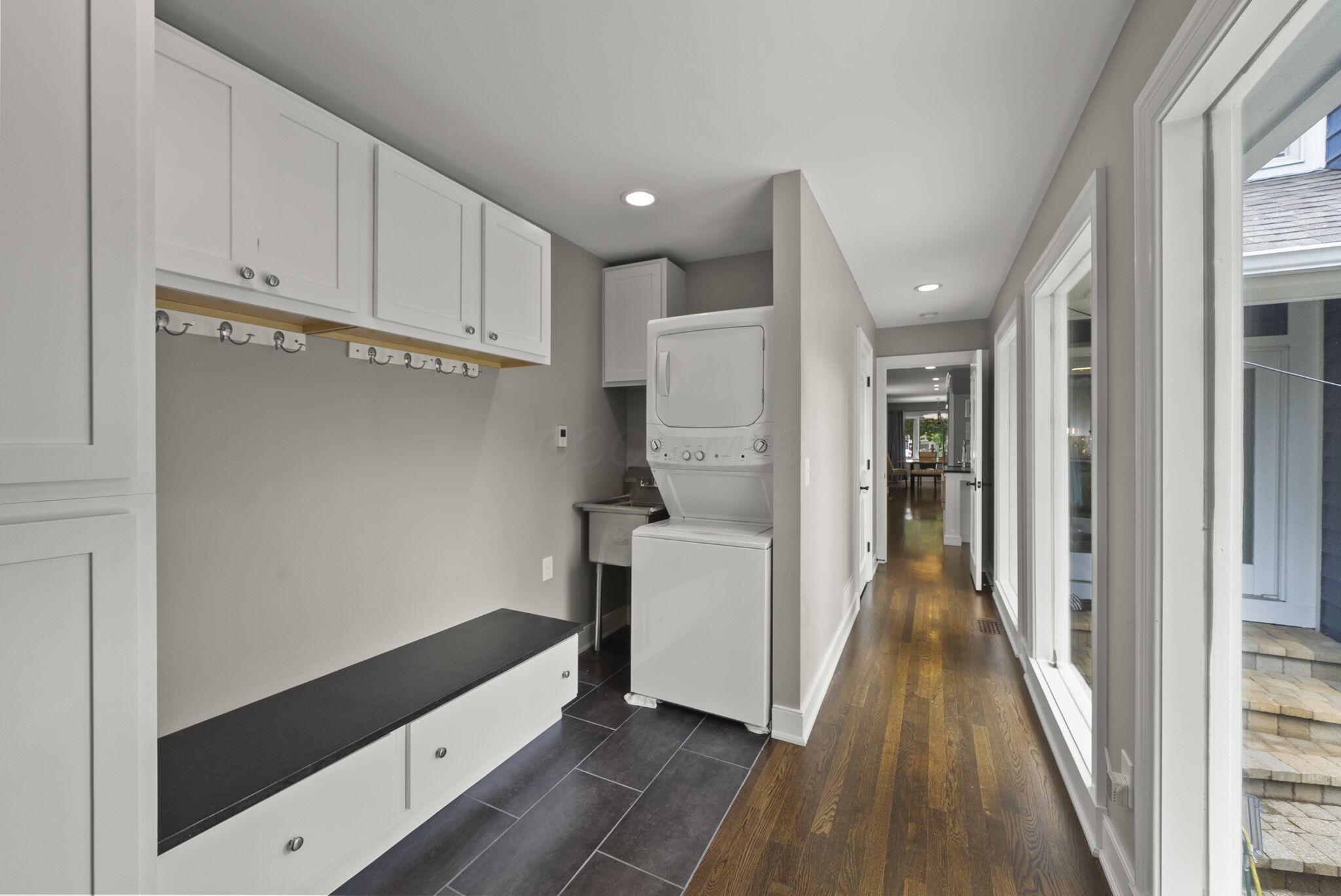 1851 Berkshire Road Columbus, OH 43221 - Photo 66 of 125 Back up the stairs through the kitchen past the half bath, floor to ceiling windows light up this hall, drop zone, fully equipped with washer and dryer, including a utility sink.