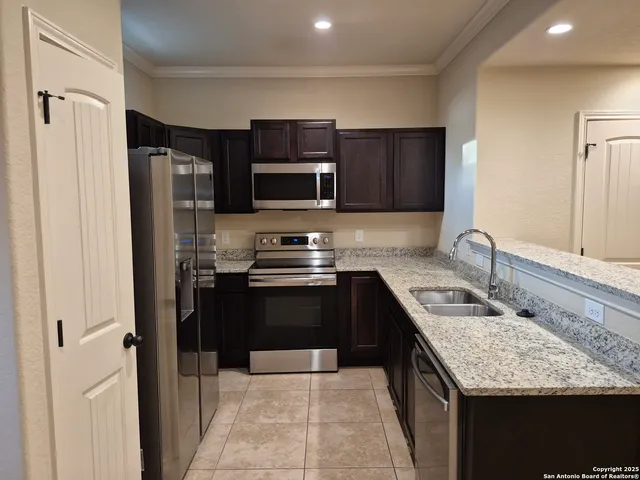 a kitchen with stainless steel appliances granite countertop a refrigerator and a stove top oven