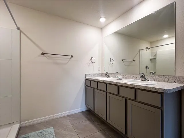 a bathroom with a double vanity sink and a mirror