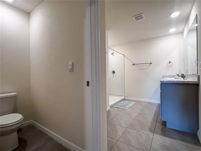 a bathroom with a granite countertop toilet and a sink