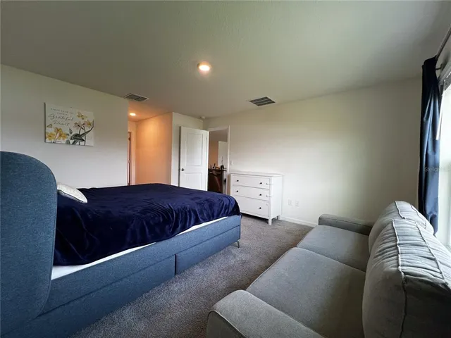 a bedroom with a bed and a couch