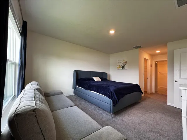 a living room with a couch and a dresser next to a window