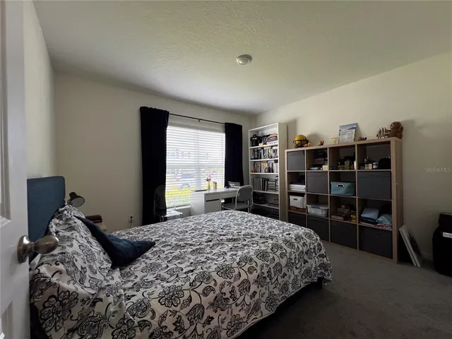 a bedroom with a large bed and a flat tv screen