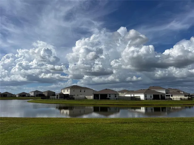 a view of a lake with houses in back