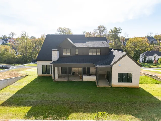 a view of a house with a big yard and large trees