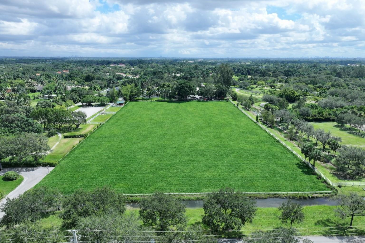 5750 Southwest 148th Avenue Southwest Ranches, FL 33330 - Photo 8 of 12 a view of a lush green yard with a building in the background