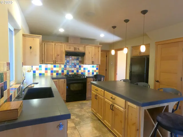 a kitchen with stainless steel appliances granite countertop a sink a stove and a refrigerator