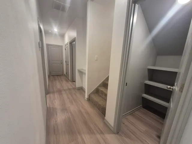 an empty room with windows and fan