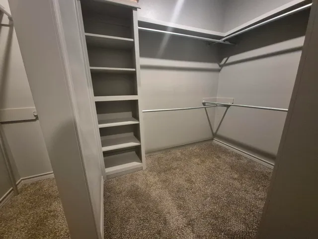 a view of walk in closet with empty racks
