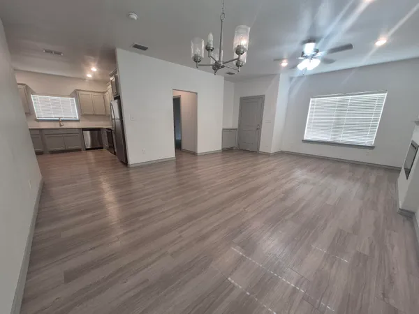 a view of a kitchen with a sink and dishwasher a refrigerator with wooden floor