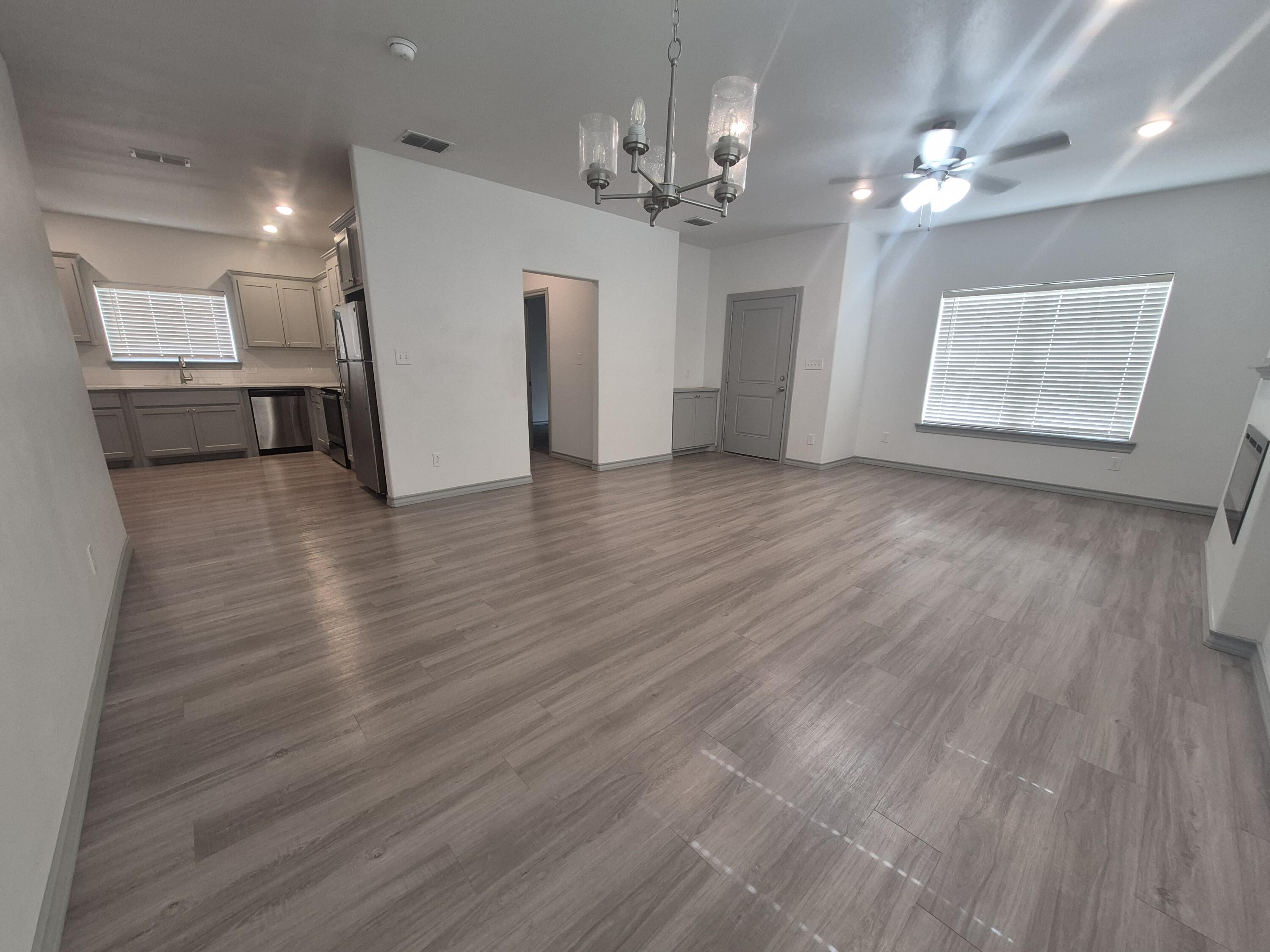 4718 125th Street Lubbock, TX 79424 - Photo 4 of 18 a view of a kitchen with a sink and dishwasher a refrigerator with wooden floor
