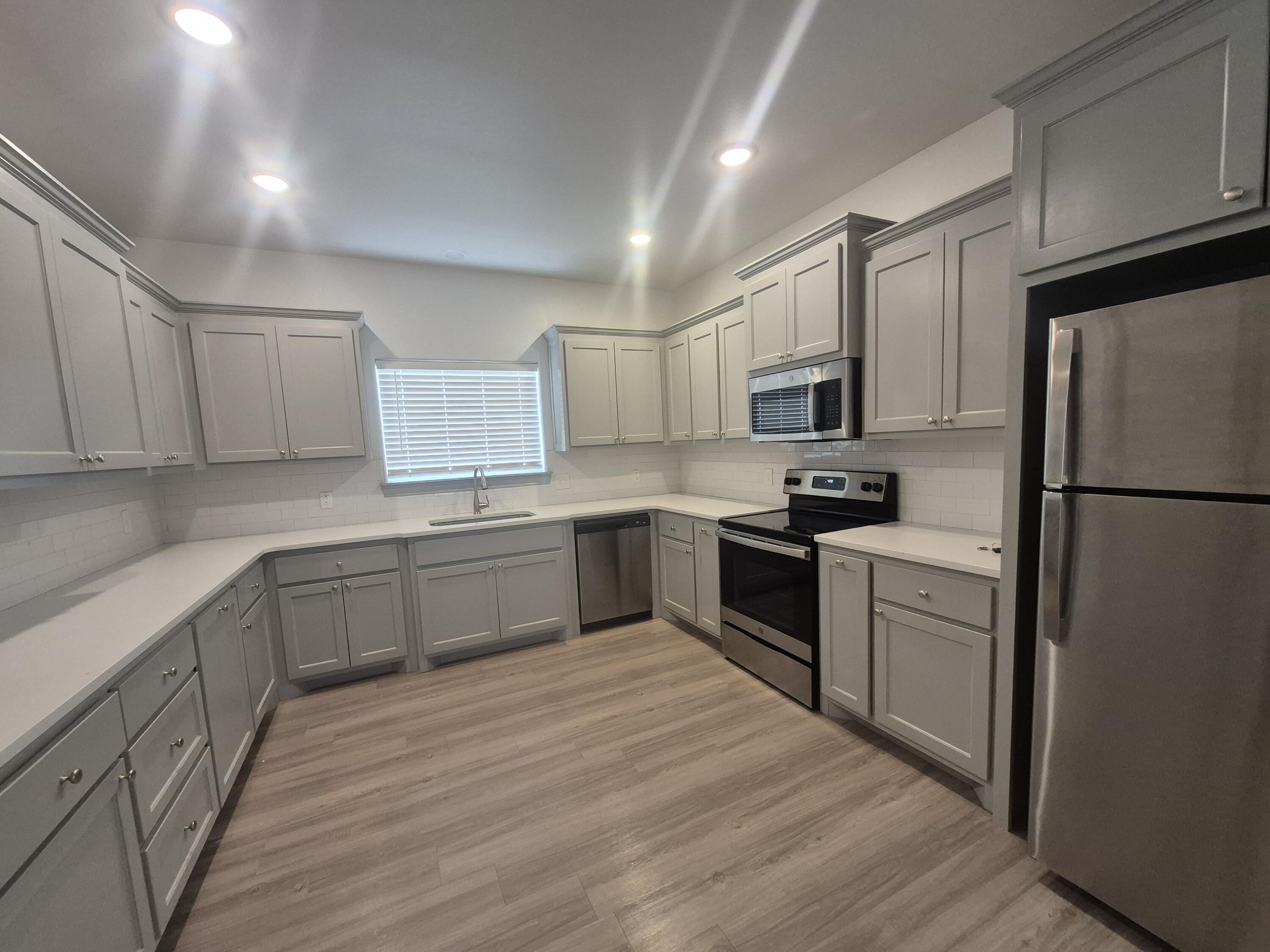 4718 125th Street Lubbock, TX 79424 - Photo 5 of 18 a kitchen with granite countertop a refrigerator stove top oven and sink