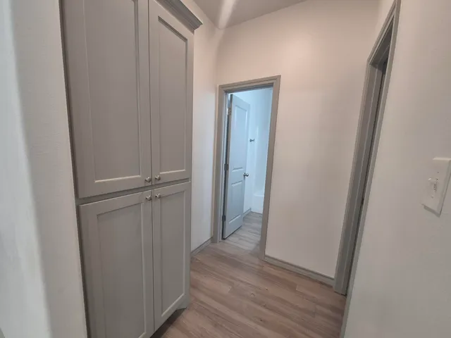 a view of a hallway with wooden floor